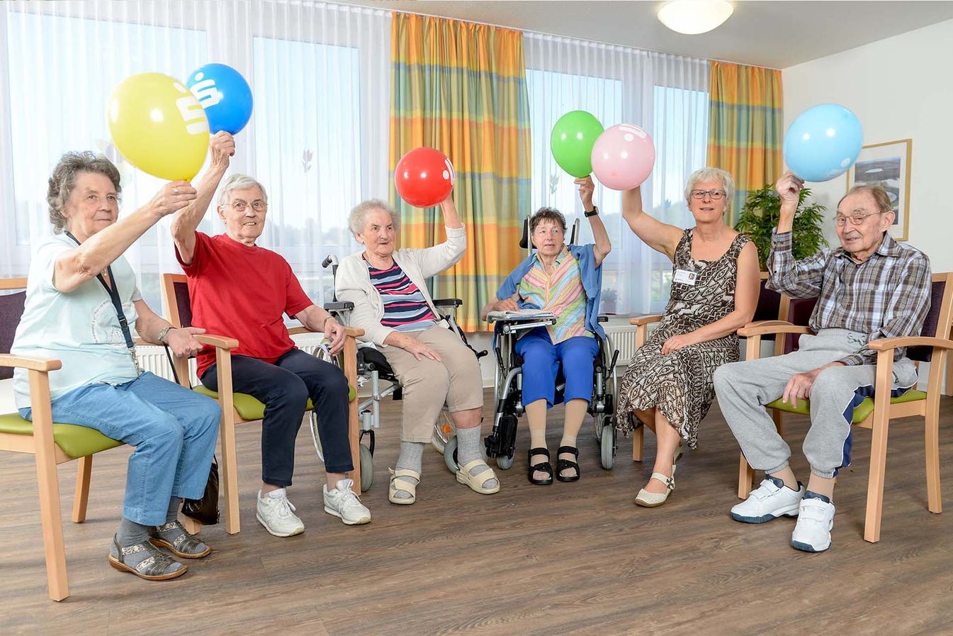 Bewohner nehmen zusammen an der Sitzgymnastik teil 