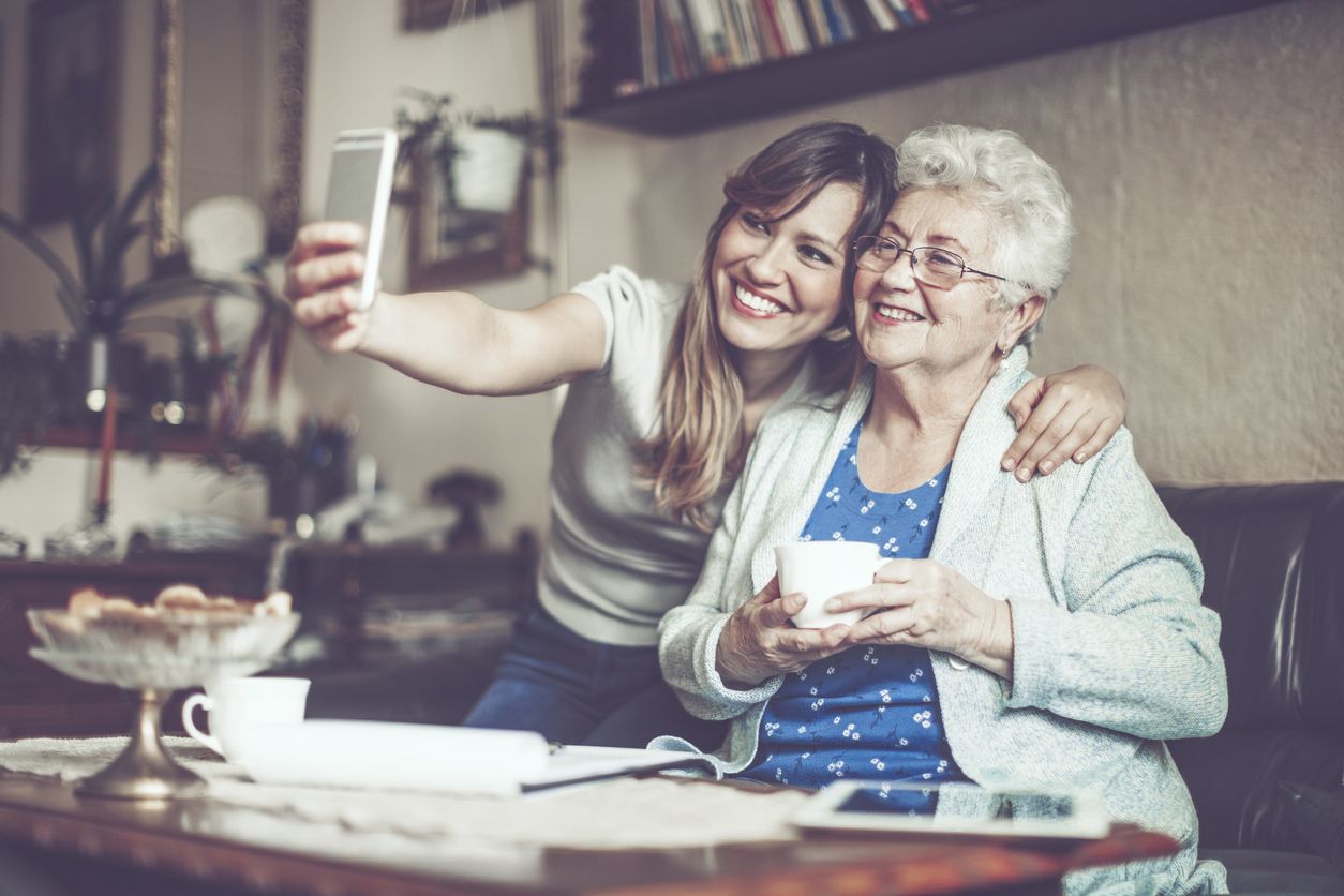 Junges Mädchen macht zusammen mit einer älteren Dame ein Foto im Wonzimmer.