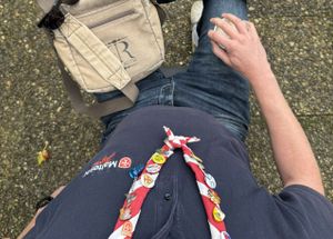 Teilansicht einer Person in Malteser Kleidung mit einem rotweißen Halstuch