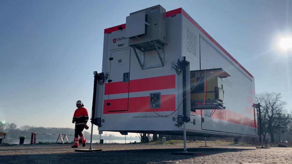 Vorschaubild zum Video über den MedExTainer – zu sehen ist der vom Trägerfahrzeug abgesetzte Container während des Absetzvorgangs auf Bodenniveau.
