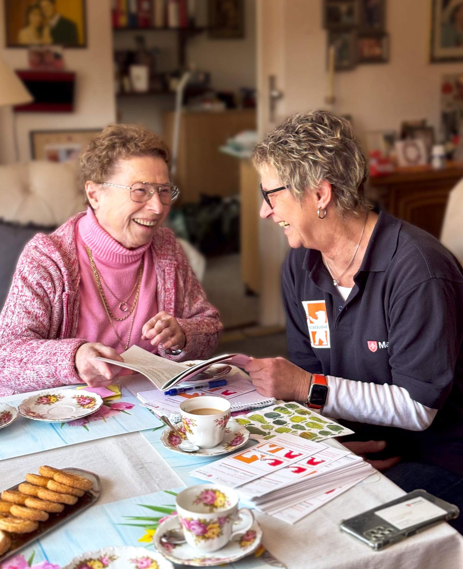 Lotsin der Berliner Hausbesuche im Gespräch mit Seniorin bei einem Hausbesuch.