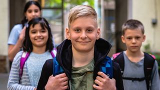 Fröhliche Kinder schauen in die Kamera.