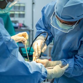 Chirurgen arbeiten konzentriert mit medizinischen Instrumenten in einem Operationssaal.