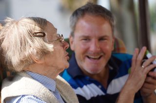 Man, der sich mit einer älteren Frau unterhält Malteser