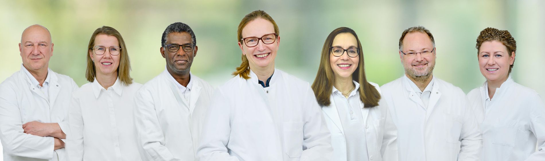 Sieben medizinische Fachkräfte der Klinik für Allgemein- und Viszeralchirurgie in weißen Kitteln stehen nebeneinander.