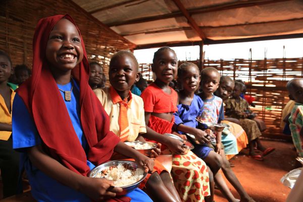 Schülerinnen und Schüler mit Mahlzeiten im Rahmen eines Projekts im Südsudan