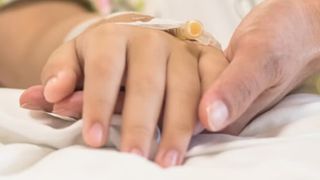 Nahaufnahme von 2 Händen, die einander halten.