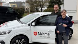 Kreisgeschäftsführer Sebastian Oberpriller und Pflegefachkraft Sabine Grundig stehen vor dem Auto der Malteser Übergangspflege in Freising