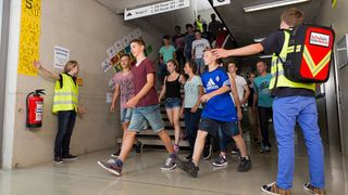 Malteser Schulsanitäter weisen Schülern den Weg im Treppenhaus. 