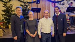 Drei Männer und eine Frau stehen auf einer Bühne.