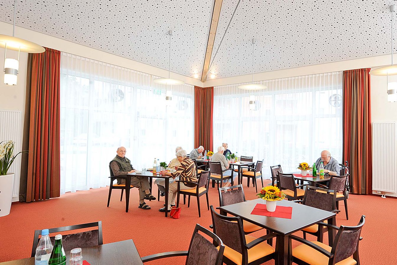 Bewohner sitzen gemeinsam in der Cafeteria 