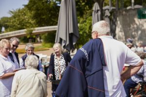 ältere Menschen stehen lächelnd zusammen in der Natur