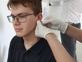 Blut wird aus dem Ohrläppchen abgenommen.