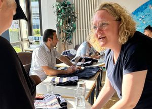 Malteser Ehrenamtliche spricht mit einer Frau des Nähworkshops