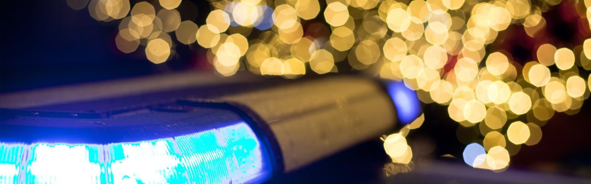 Das Blaulicht eines Einsatzfahrzeugs vor weihnachtlichen Lichtern.