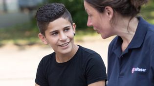 Eine junge Malteser Integrationslotsin unterhält sich mit einem Jungen.