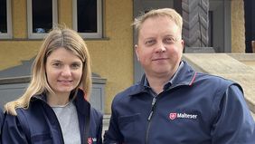 Eine Frau und ein Mann in Malteserjacken stehen nebenenander.