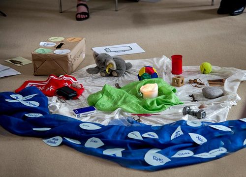 Ein Tuch mit verschiedenen Symbolen zum Thema Trauer liegt auf dem Boden