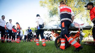 Bei einer Katastrophenschutzübung transportieren Malteser einen Verletzten auf einer Wiese