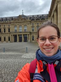 Natalie Henning steht vor in Malteser Einsatzkleidung vor der Würzburger Residenz.