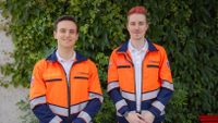 Zwei Männer in Dienstbekleidung des Rettungsdienst blicken freundlich in die Kamera.