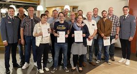 Gruppe von Helferinnen und Helfern mit Urkunden in den Händen