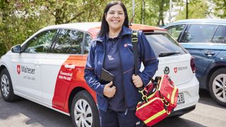 Malteser Hausnotruf Bereitschaftsdienstmitarbeiterin lächelt in die Kamera.