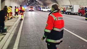 Eine Frau in Malteser-Einsatzkleidung beobachtet eine Einsatzübung in einem Tunnel.