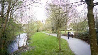 Ehrenamtlerin spaziert mit einer Frau durch den Wald.