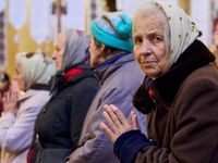 Mehrere ältere Frauen. Eine Frau schaut in die Kamera