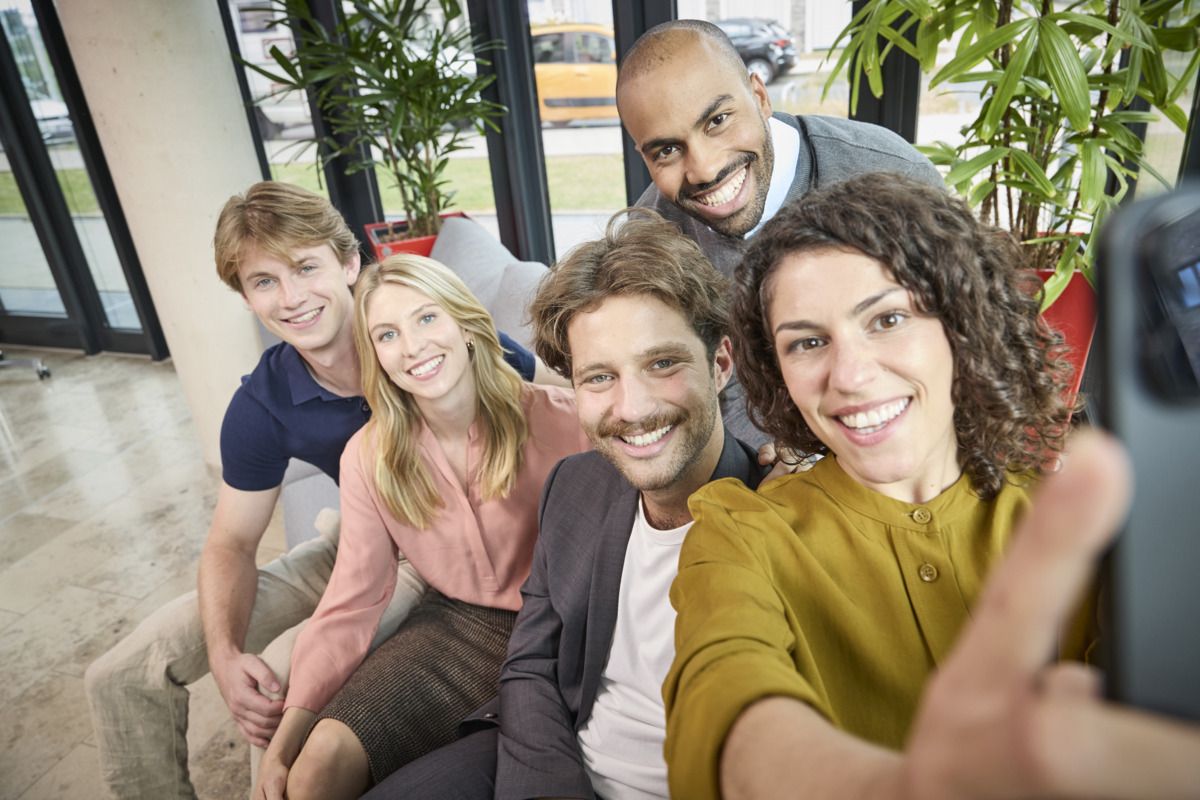 Gruppe von Malteser-Trainees beim gemeinsamen Selfie auf dem Sofa