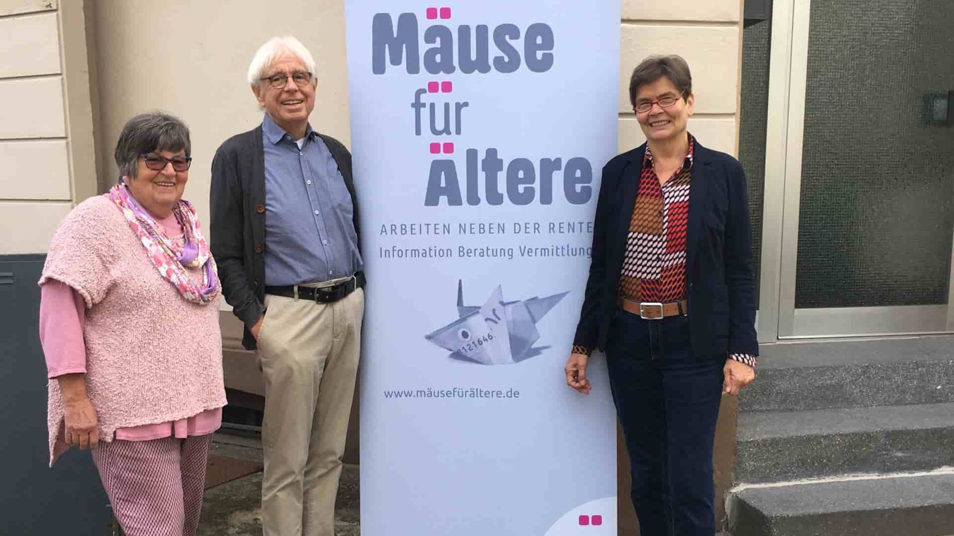 Drei Senioren werben für ein Straßenplakat mit dem Titel: Mäuse für Ältere.