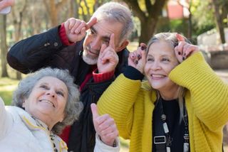 2 ältere Frauen und ein Mann machen ein lustiges Selfie