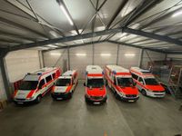 Rettungsfahrzeuge des Malteser Hilfsdienstes Neuwied stehen in einer Halle