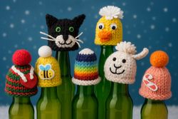 Sieben verschiedene Mini-Strickmützchen auf Flaschenhälsen (Foto: Malteser Speyer)