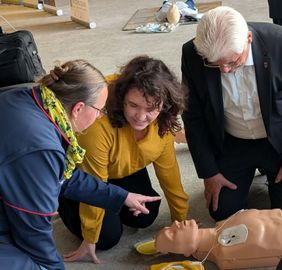 Eine Ausbilderin der Malteser zeigt Abgeordnete Wiederbelebung an einem Modell