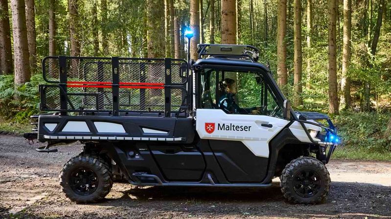 Ein ATV steht auf einer Schotterstraße im Wald.