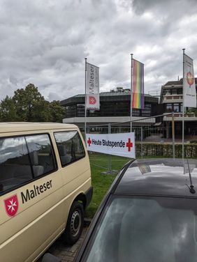 MTW der Malteser Aurich vor einem Banner "Heute Blutspende"