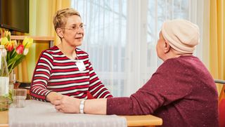 Zwei Frauen sitzen sich gegenüber und unterhalten sich