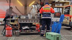 Menschen kochen an einer Feldküche.