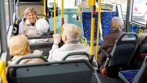 Eine Gruppe älterer Menschen in einem öffentlichen Bus.