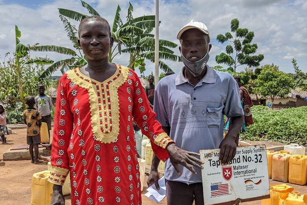 Mary Night steht vor der Wasserstelle in Uganda