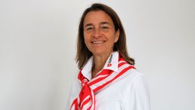 Eine Frau in weißer Bluse lächelt in die Kamera.