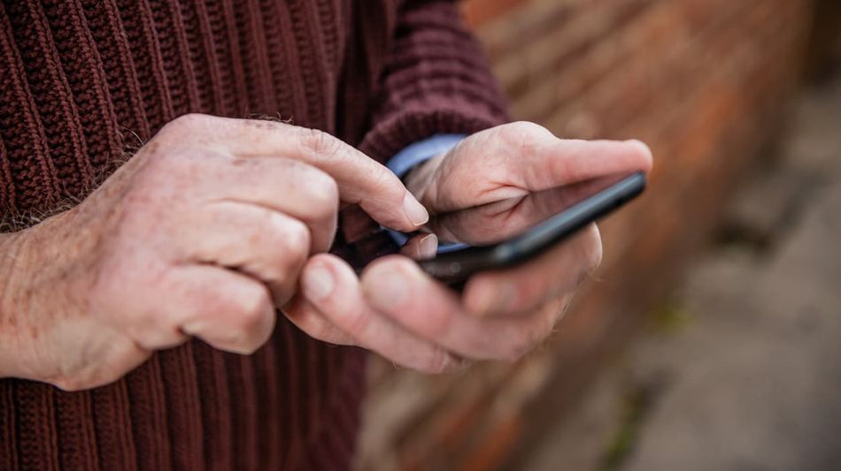Hände halten und steuern Handy.