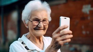 Eine alte Frau blickt auf ein Smartphone.