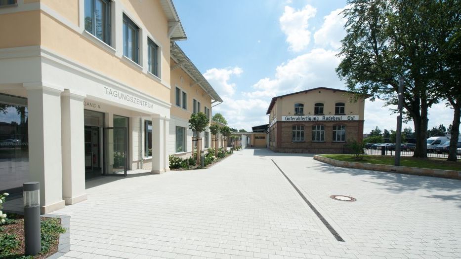 Eingangsbereich des Tagungszentrums der Sächsischen Wirtschaft mit moderner Fassade und Vorplatz in Radebeul.