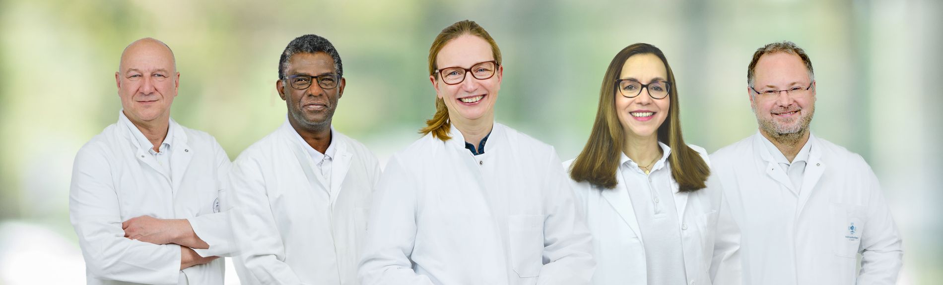 Fünf medizinische Fachkräfte der Klinik für Allgemein- und Viszeralchirurgie in weißen Kitteln stehen nebeneinander.
