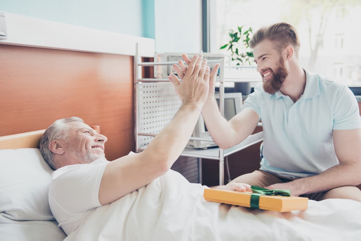 Junger Mann gibt Pflegebedürftigem ein High Five