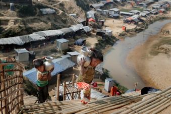 Zwei kleine Jungen tragen Wasserkrüge in einem Flüchtlingscamp.