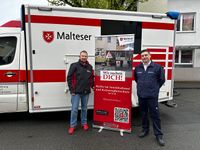 Bildunterschrift: Markus Härmes, MGrafix, und Oliver Baumann, Malteser, vor einem Einsatzfahrzeug der Malteser. (Foto: Malteser Brakel)